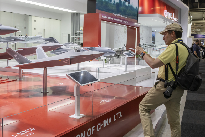Мужчина фотографирует модель истребителя J-35A, представленного среди других моделей военных самолетов, на стенде AVIC в выставочном павильоне 55-го Парижского авиасалона в аэропорту Ле-Бурже