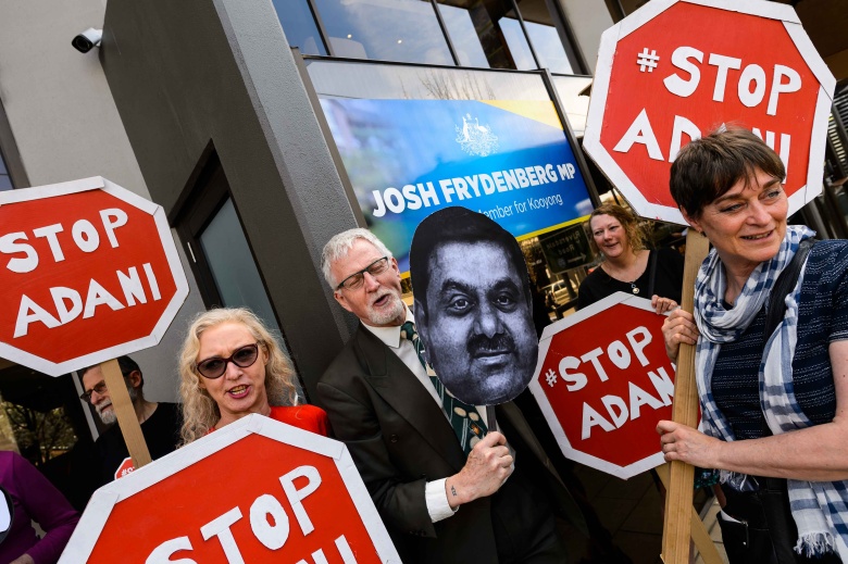 Протестующие в Австралии держат портрет Гаутама Адани.  В 2017 году активисты в Квинсленде пытались противостоять инвестициям Adani Group  в местную угольную промышленность