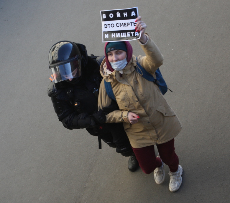 Росгвардеец задерживает участницу антивоенной акции, у неё в руках плакат с надписью "Война это смерть и нищета". Санкт-Петербург, 7 марта 2022 года. Фото: Zamir Usmanov / Global Look Press