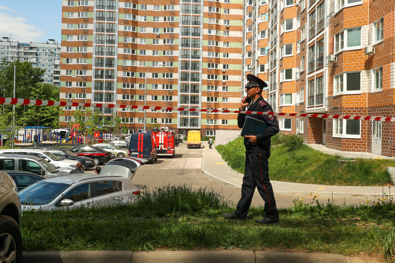 Сотрудник полиции на месте попадания беспилотника в многоэтажный жилой дом, Москва, 30 мая 2023 года