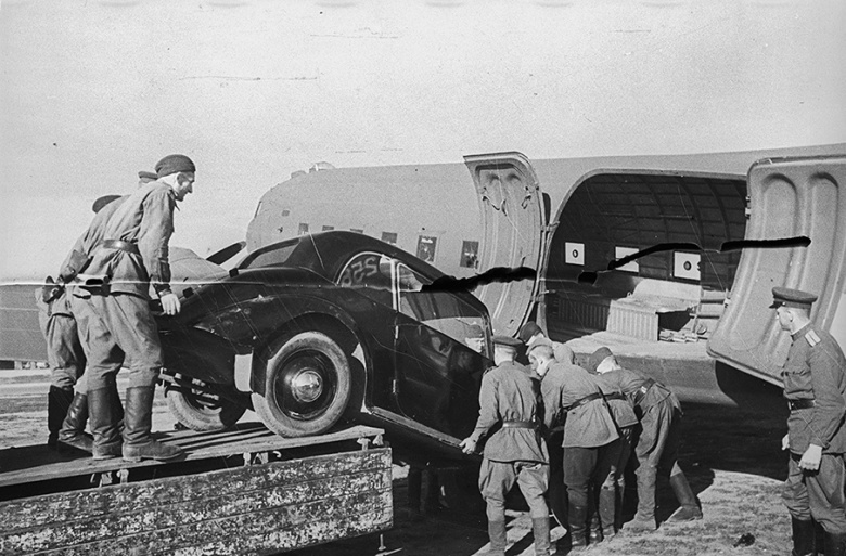 Советские военнослужащие грузят в самолет «трофейный» немецкий автомобиль