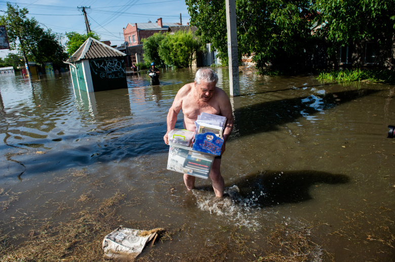 Херсон, 7 июня 2023 года. Мужчина спасает от наводнения семейный архив на следующий день после подрыва Новокаховской ГЭС