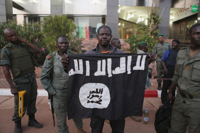 Охранники показывают флаг, оставленный террористами в отеле.