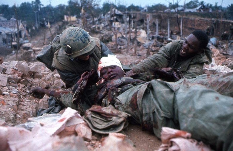 Морпехи-афроамериканцы помогают раненому товарищу во время Тэтского наступления. Хюэ, 1968 год