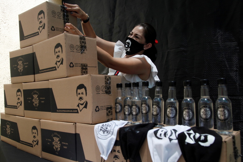 Женщина укладывает коробки с гуманитарной помощью. На коробках - изображение наркобарона Эль Чапо. Гвадалахара, Мексика. Фото: Francisco Guasco / EPA / TASS