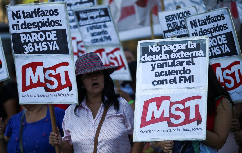 Женщина с плакатами «Нет выплатам иностранному долгу»  и «Отменить соглашение с МВФ» во время протеста в Буэнос-Айресе. Фото: Agustin Marcarian / Reuters