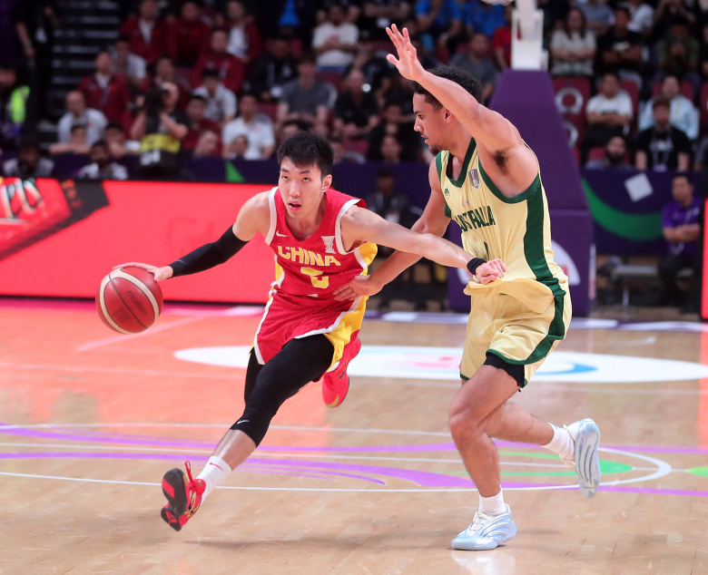 Ляо Саньнин (слева) из Китая прорывается в финальном матче между Китаем и Австралией на Кубке Азии