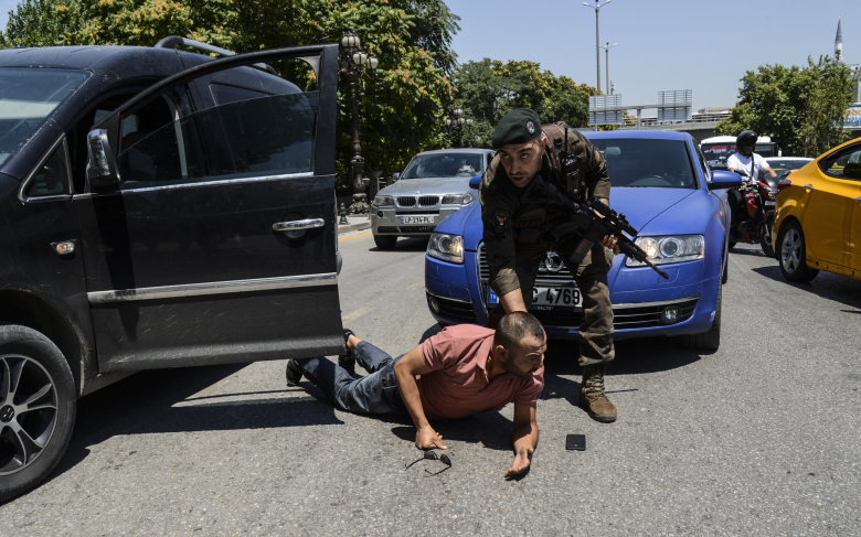 Полицейский останавливает для досмотра мужчину, Анкара