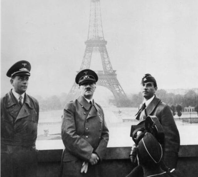 Гитлер позирует на фоне Эйфелевой башни в Париже.