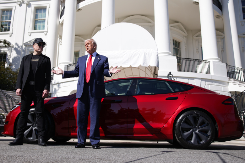 Вашингтон, 11 марта 2025 года. Президент США Дональд Трамп позирует на фоне электромобиля Tesla в знак поддержки владельца одноименной компании Илона Маска. Трамп объявил, что купит эту машину на фоне поджогов зарядных станций Tesla и призывов бойкотировать ее продукцию