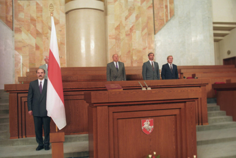 Александр Лукашенко (слева) готовится в первый раз принести президентскую присягу. Видны ещё официальные для республики БЧБ-флаг и герб «Погоня». 20 июля 1994 года