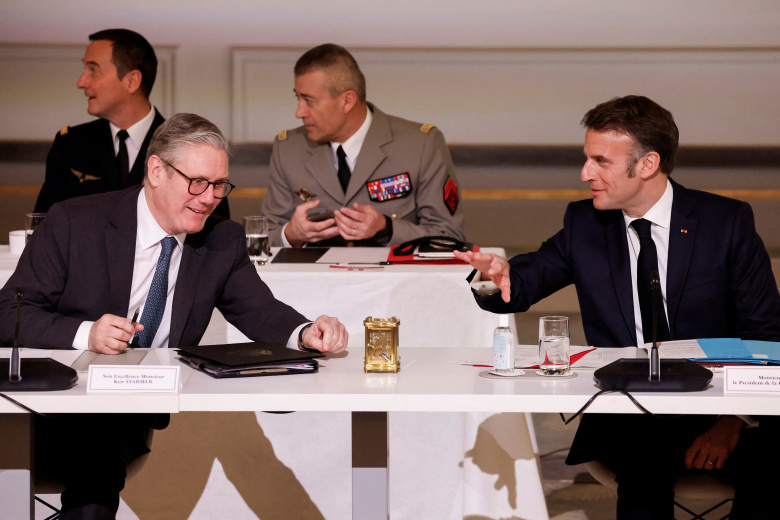 Президент Франции Эммануэль Макрон перекидывается фразами с премьер-министром Великобритании Киром Стармером на саммите "Коалиции желающих" в Париже"
