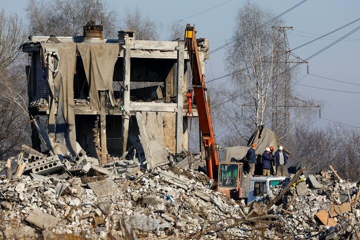Разбор завалов на месте разрушенного здания ПТУ в украинской Макеевке