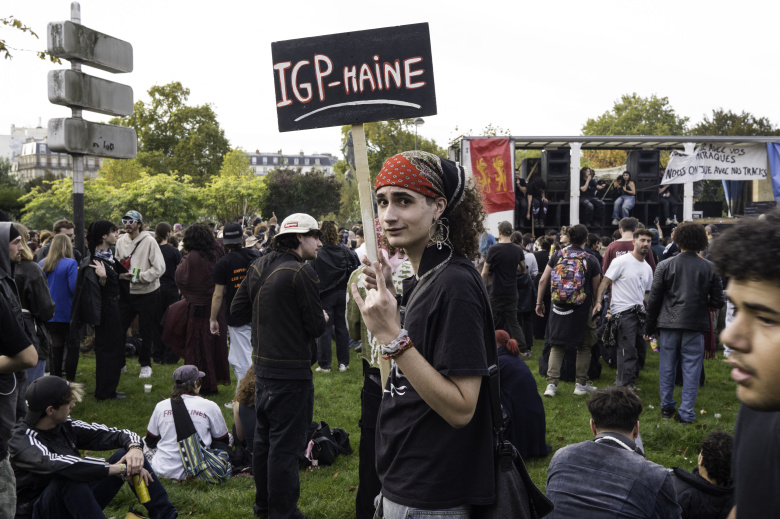 Франция, Париж, 18 октября 2025 года. Молодой человек держит плакат с надписью «IGP-Haine» среди множества демонстрантов. После отмены официального техно-парада молодые люди организовали демонстрацию, чтобы защитить право на вечеринки и выразить протест против полицейского насилия