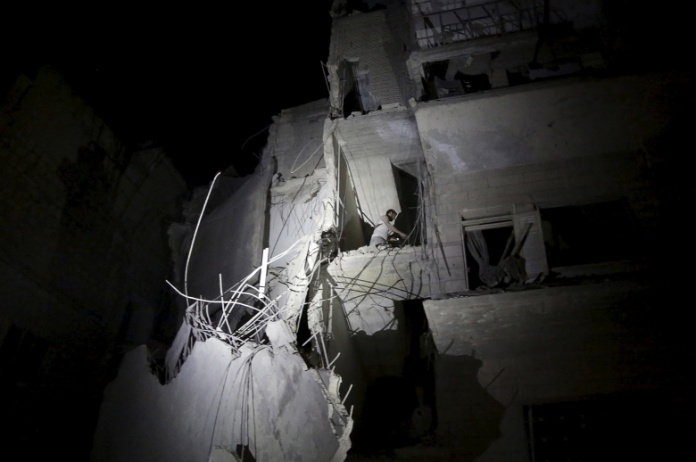 Мужчина на обломках здания, разбомбленного силами войск Башара Асада. Мааррет-эн-Нууман, 4 июня 2015.
