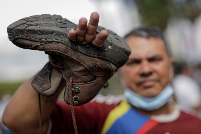 Демонстрант показывает свой рваный ботинок на акции протеста работников государственного сектора. Каракас, Венесуэла, 11 августа 2022 года