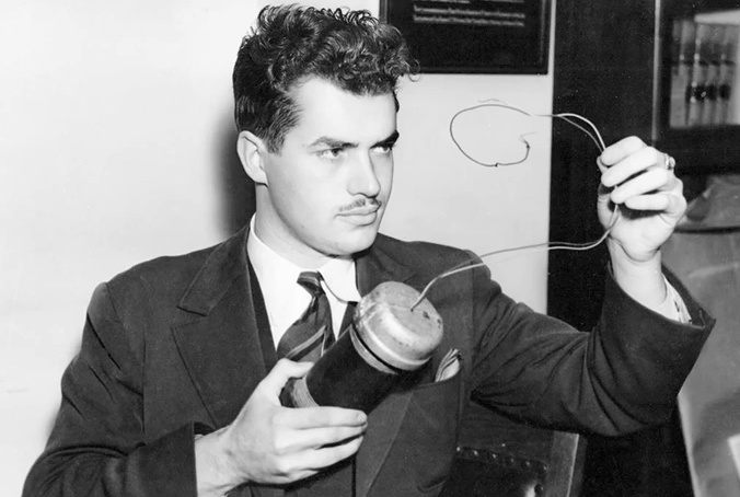 Джон Парсонс держит модель автомобильной бомбы, использовавшуюся в судебном процессе против капитана Эрла Кайнетта (1938). Фото: Wikipedia