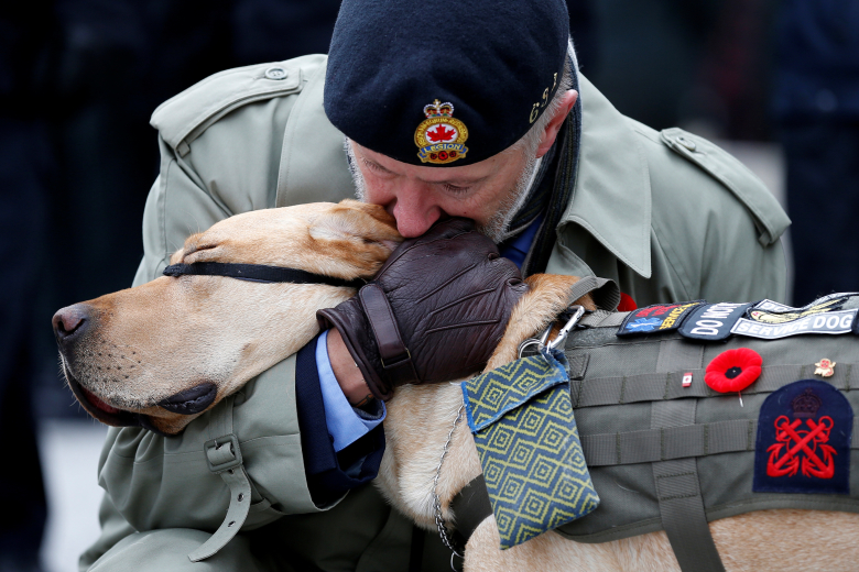 Ветеран со служебной собакой на дне памяти в Национальном военном мемориале, Оттава, Канада. Фото: Chris Wattie / Reuters