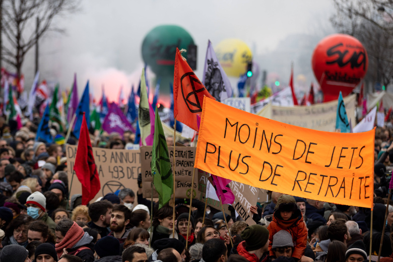 Демонстранты держат плакат с надписью «Меньше самолетов, больше пенсии» во время акции протеста против плана пенсионной реформы, объявленного правительством премьер-министра Франции Элизабет Борн. Париж, Франция, 19 января 2023 года