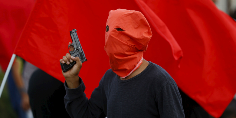 Вооруженный мужчина на похоронах жертв теракта в Суруче.