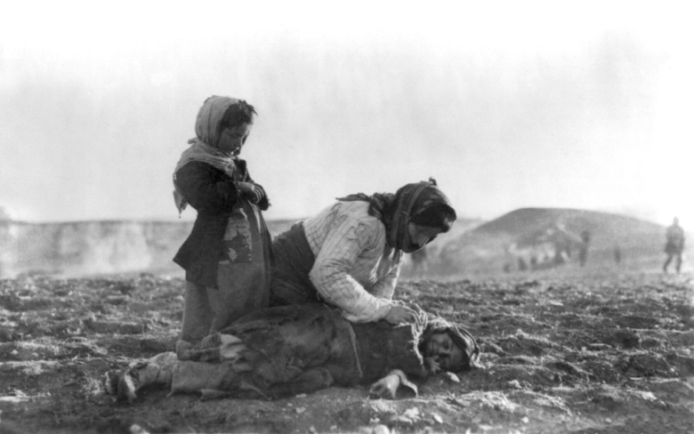 Армянка стоит на коленях у детского трупа в лагере для депортированных, Алеппо, около 1917 года