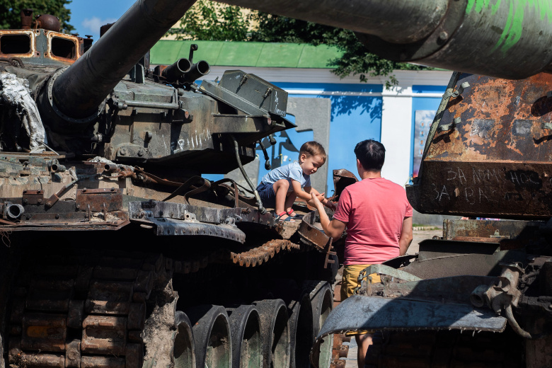 Мальчик играет на крыше российского танка, подбитого украинскими войсками, Киев, 2 сентября 2022 года