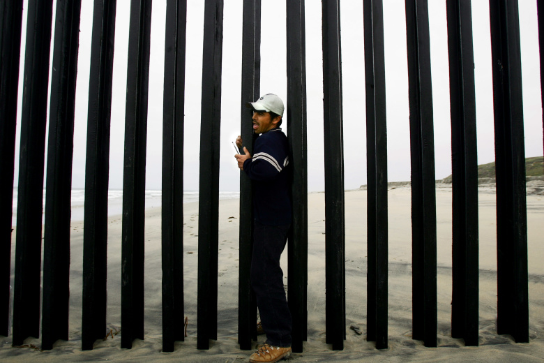 Мексиканец пытается пересечь границу с США. Фото: Carlos Barria / Reuters
