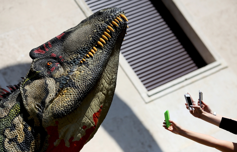 Прохожие фотографируют макет динозавра, Рим, Италия